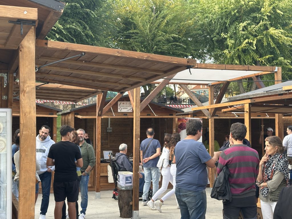 Sombreado modular de madera entre casetas en feria al aire libre con público